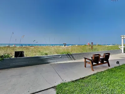 a bench sitting on a sidewalk next to a beach at Continental 107 in Panama City Beach