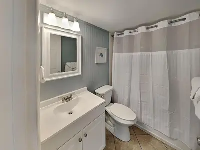 a white bathroom with a toilet and a sink at Continental 107 in Panama City Beach