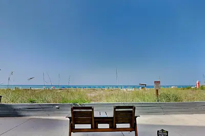 a bench sitting on a sidewalk next to a beach at Continental 107 in Panama City Beach