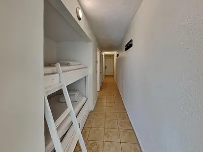 a small room with a hallway with bunk beds at Summit Beach Resort #1102 in Panama City Beach