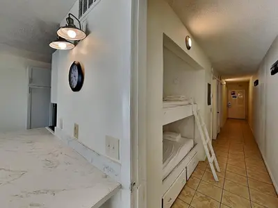 a room with a bed and a clock on a wall at Summit Beach Resort #1102 in Panama City Beach