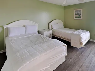 two beds in a room with green walls at Edgewater Tower Ii 510 in Panama City Beach