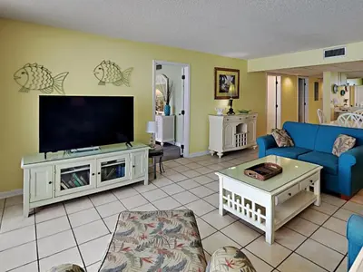 a living room with a blue couch and a flat screen tv at Edgewater Tower Ii 510 in Panama City Beach