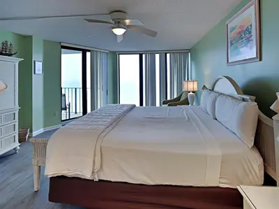 a bedroom with a large bed with a ceiling fan at Edgewater Tower Ii 510 in Panama City Beach