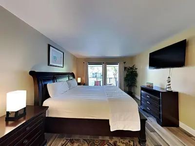 a bedroom with a large bed and a flat screen tv at Edgewater Villa #2112 in Panama City Beach