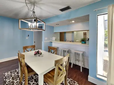 a dining room with a white table and chairs at Edgewater Villa #407 in Panama City Beach