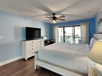 a bedroom with a bed and a flat screen tv at Edgewater Villa #407 in Panama City Beach