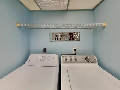 a laundry room with two machines and a shelf at Edgewater Villa #407 in Panama City Beach