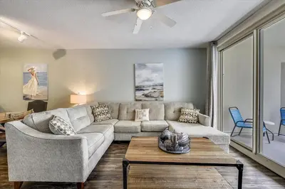 a living room with a couch and a table at Shores of Panama 328 - Low Floor HUGE 3 BedroomBunk Room, Reserved Parking, condo in Panama City Beach