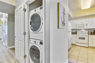 a white laundry room with a washer and dryer at Shores of Panama 2025 - 1 Bedroom Bunks Sleeps 6, Reserved Parking, Free Fun! condo in Panama City Beach
