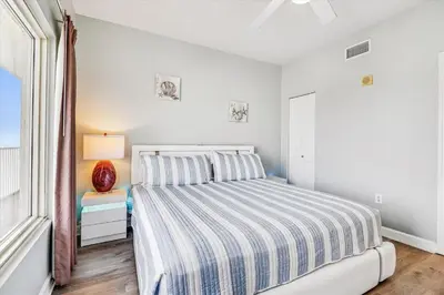 a white bedroom with a bed and a window at Shores of Panama 2025 - 1 Bedroom Bunks Sleeps 6, Reserved Parking, Free Fun! condo in Panama City Beach