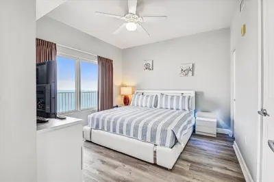a white bedroom with a bed and a television at Shores of Panama 2025 - 1 Bedroom Bunks Sleeps 6, Reserved Parking, Free Fun! condo in Panama City Beach
