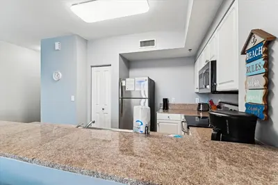 a kitchen with a counter top and a refrigerator at Shores of Panama 2327 - 1 BedroomBunks and Sleeper Sofa, Sunset View! Free Fun! condo in Panama City Beach