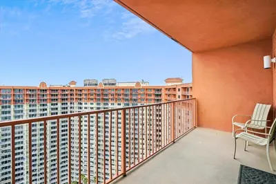 a balcony with a chair and a large building at Shores of Panama 2327 - 1 BedroomBunks and Sleeper Sofa, Sunset View! Free Fun! condo in Panama City Beach