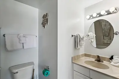a white bathroom with a sink and a mirror at Shores of Panama 2327 - 1 BedroomBunks and Sleeper Sofa, Sunset View! Free Fun! condo in Panama City Beach
