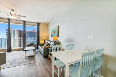 a living room with a table and a couch at Shores of Panama 2026 - 1 BedroomBunksSleeps 6, Res, Parking! condo in Panama City Beach