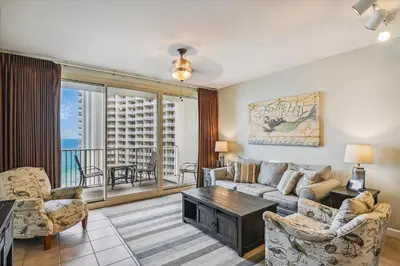 a living room with a couch and chairs and a balcony at Shores of Panama 1418 - 2 BedroomBunkroom Sleeps8! Updated with a View! Free Fun! condo in Panama City Beach