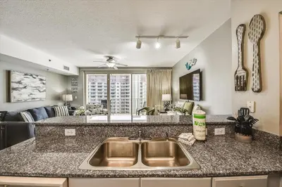 a kitchen with a sink and a living room at Shores of Panama 1704 - 2 Bedroom Bunk Room Sleeps 8, Updated! Res, Parking condo in Panama City Beach