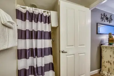 a bathroom with a striped shower curtain next to a door at Shores of Panama 1704 - 2 Bedroom Bunk Room Sleeps 8, Updated! Res, Parking condo in Panama City Beach