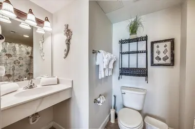 a white bathroom with a toilet and a sink at Shores of Panama 1704 - 2 Bedroom Bunk Room Sleeps 8, Updated! Res, Parking condo in Panama City Beach
