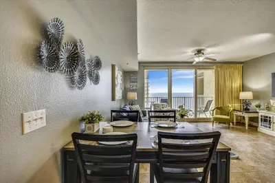 a dining room and living room with a table and chairs at Shores of Panama 1704 - 2 Bedroom Bunk Room Sleeps 8, Updated! Res, Parking condo in Panama City Beach