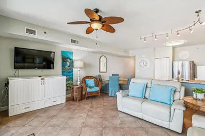 a living room with a couch and a ceiling fan at Shores of Panama 521 - 2 Bedroom Bunks Sleeps 6, Reserved Parking! condo in Panama City Beach
