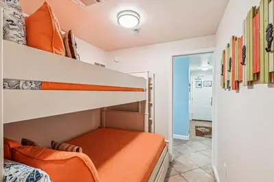 a bedroom with a bunk bed with an orange mattress at Shores of Panama 521 - 2 Bedroom Bunks Sleeps 6, Reserved Parking! condo in Panama City Beach