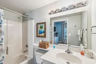 a bathroom with a sink and a toilet and a mirror at Shores of Panama 521 - 2 Bedroom Bunks Sleeps 6, Reserved Parking! condo in Panama City Beach