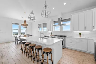 a kitchen with white cabinets and a large island with bar stools at Beach Gulf Views with a 3rd Floor Pool - Mala House - Inlet Beach, FL home in Inlet Beach