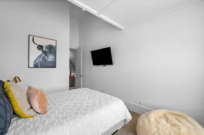 a bedroom with a bed and a tv on the wall at Beach Gulf Views with a 3rd Floor Pool - Mala House - Inlet Beach, FL home in Inlet Beach