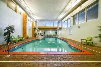 an indoor swimming pool in a building with tables and chairs at Shores of Panama 314 - 1 BdBunks, Sleeps 6, Same Level Parking, Free Fun! condo in Panama City Beach
