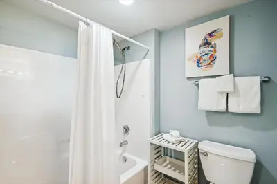 a bathroom with a white shower curtain and a toilet at Shores of Panama 630-1BdBunks, Sleeps 6, Beach Front! Free Fun! Reserved Parking Space condo in Panama City Beach