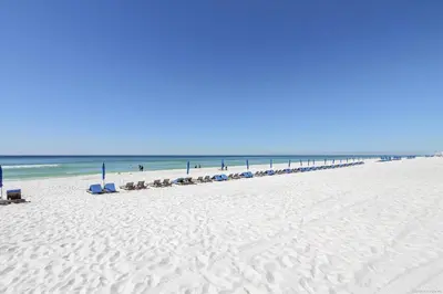 a beach with a line of beach chairs and the ocean at Shores of Panama 630-1BdBunks, Sleeps 6, Beach Front! Free Fun! Reserved Parking Space condo in Panama City Beach