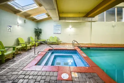 a swimming pool in a room with chairs and a table at Shores of Panama 630-1BdBunks, Sleeps 6, Beach Front! Free Fun! Reserved Parking Space condo in Panama City Beach