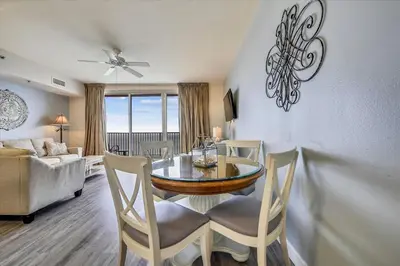 a dining room with a table and chairs and a couch at Shores of Panama 2330 - 1 Bedroom Bunk Area Sleeps 6, Beautiful Direct Beach View! Free Fun! condo in Panama City Beach