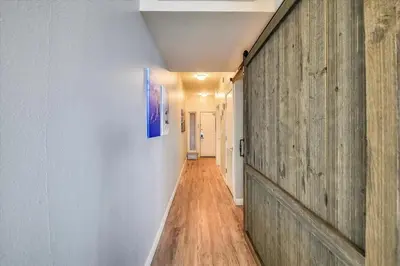 a hallway with a wooden wall and a painting on the wall at Shores of Panama 2330 - 1 Bedroom Bunk Area Sleeps 6, Beautiful Direct Beach View! Free Fun! condo in Panama City Beach