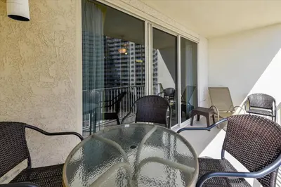 a glass table and chairs on a balcony at Shores of Panama 707 - 2 BedroomBunks Sleeps 8, Reserved Parking Free Fun! condo in Panama City Beach