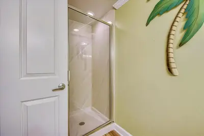 a shower with a glass door and a snake on the wall at Shores of Panama 707 - 2 BedroomBunks Sleeps 8, Reserved Parking Free Fun! condo in Panama City Beach