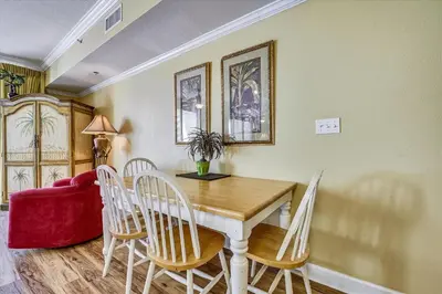 a dining room table with chairs and a red couch at Shores of Panama 707 - 2 BedroomBunks Sleeps 8, Reserved Parking Free Fun! condo in Panama City Beach