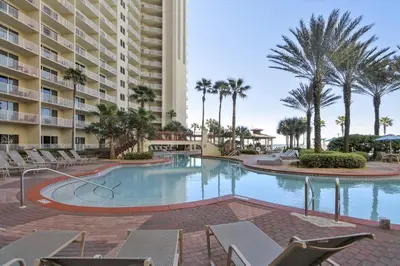 a swimming pool with chairs and a large building at Shores of Panama 707 - 2 BedroomBunks Sleeps 8, Reserved Parking Free Fun! condo in Panama City Beach