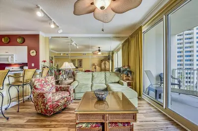a living room with a couch and a table at Shores of Panama 707 - 2 BedroomBunks Sleeps 8, Reserved Parking Free Fun! condo in Panama City Beach