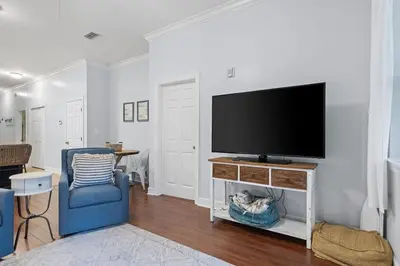 a living room with a tv and a blue chair at Happy Days - Seagrove Highlands in Santa Rosa Beach