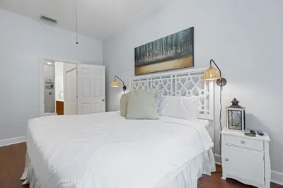 a white bedroom with a large white bed with a white headboard at Happy Days - Seagrove Highlands in Santa Rosa Beach