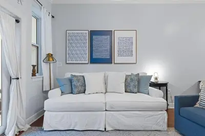 a living room with a white couch and a blue chair at Happy Days - Seagrove Highlands in Santa Rosa Beach