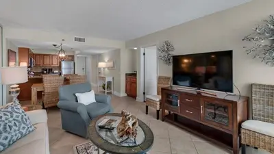 a living room with a tv and a couch and a table at Beachcrest 405 in Santa Rosa Beach