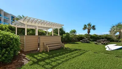 a pergola and a bench in a yard at Beachcrest 405 in Santa Rosa Beach