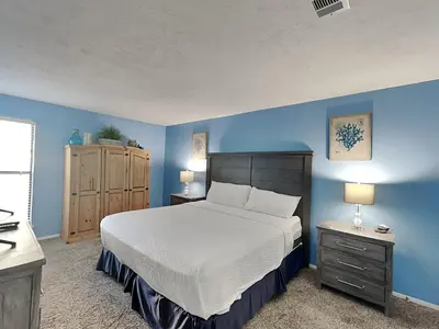 a bedroom with a large bed and blue walls at Endless Summer #A27 in Panama City Beach