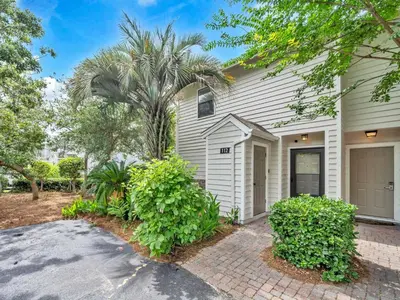 a house with a palm tree and a driveway at Cassine Gardens 112- 30A Imagine Ocean in Santa Rosa Beach