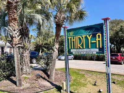 a sign in front of a parking lot with palm trees at Cassine Gardens 112- 30A Imagine Ocean in Santa Rosa Beach