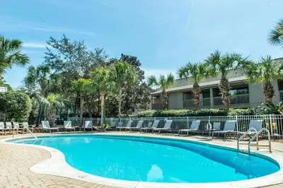 a swimming pool with chairs and a building at Cassine Gardens 112- 30A Imagine Ocean in Santa Rosa Beach